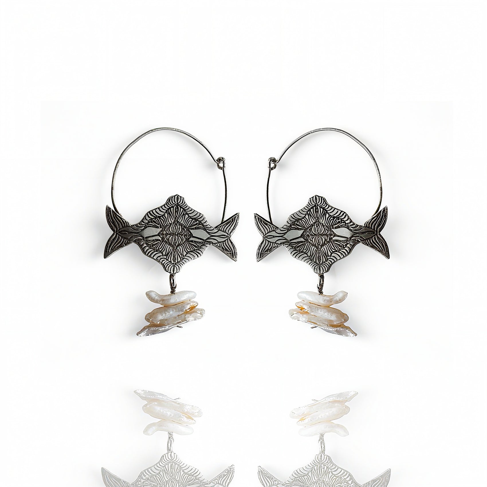 Pair of fish-shaped earrings with shell elements on a white background