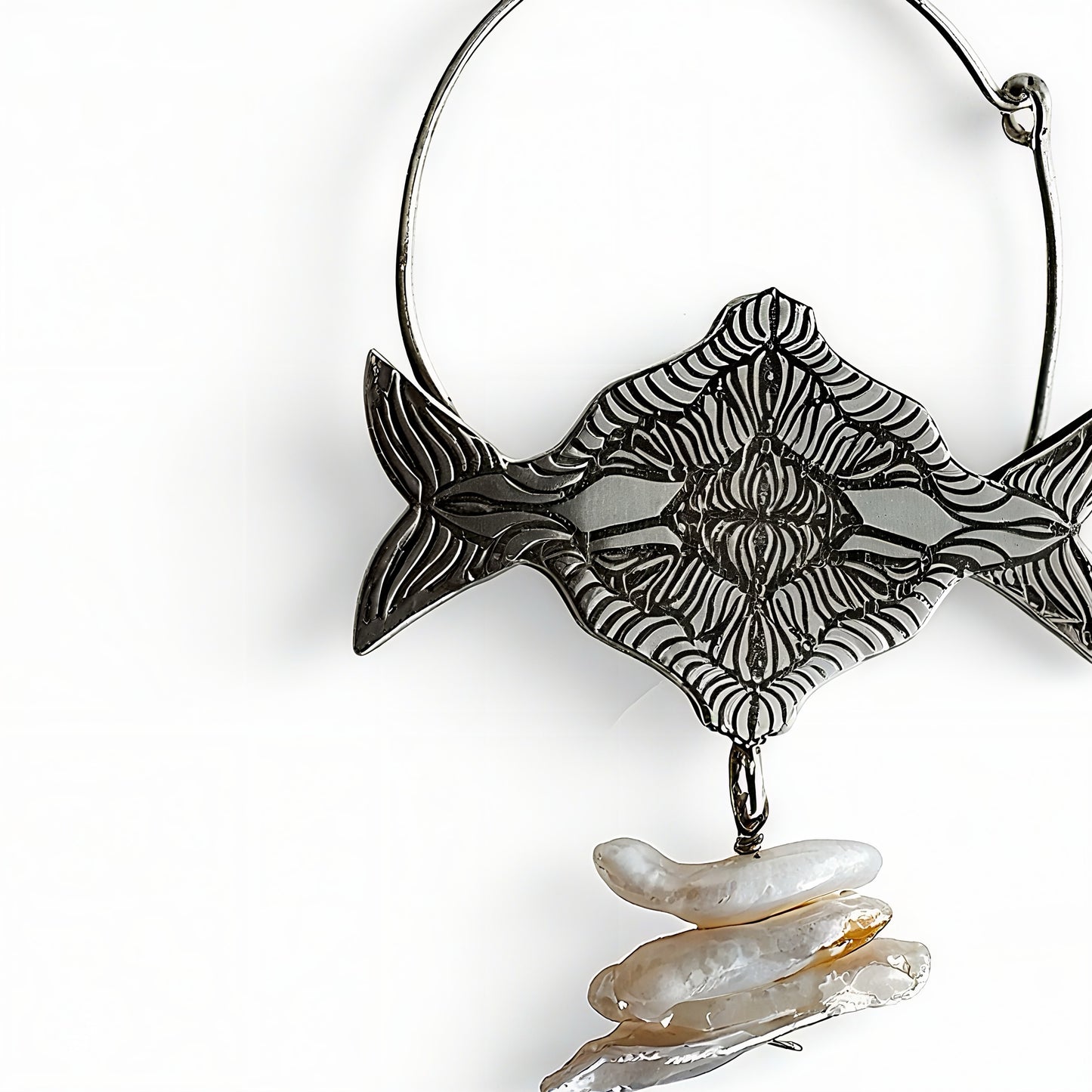 Decorative silver earrings with fish design and pearls on a white background