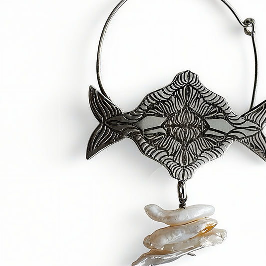 Decorative silver earrings with fish design and pearls on a white background