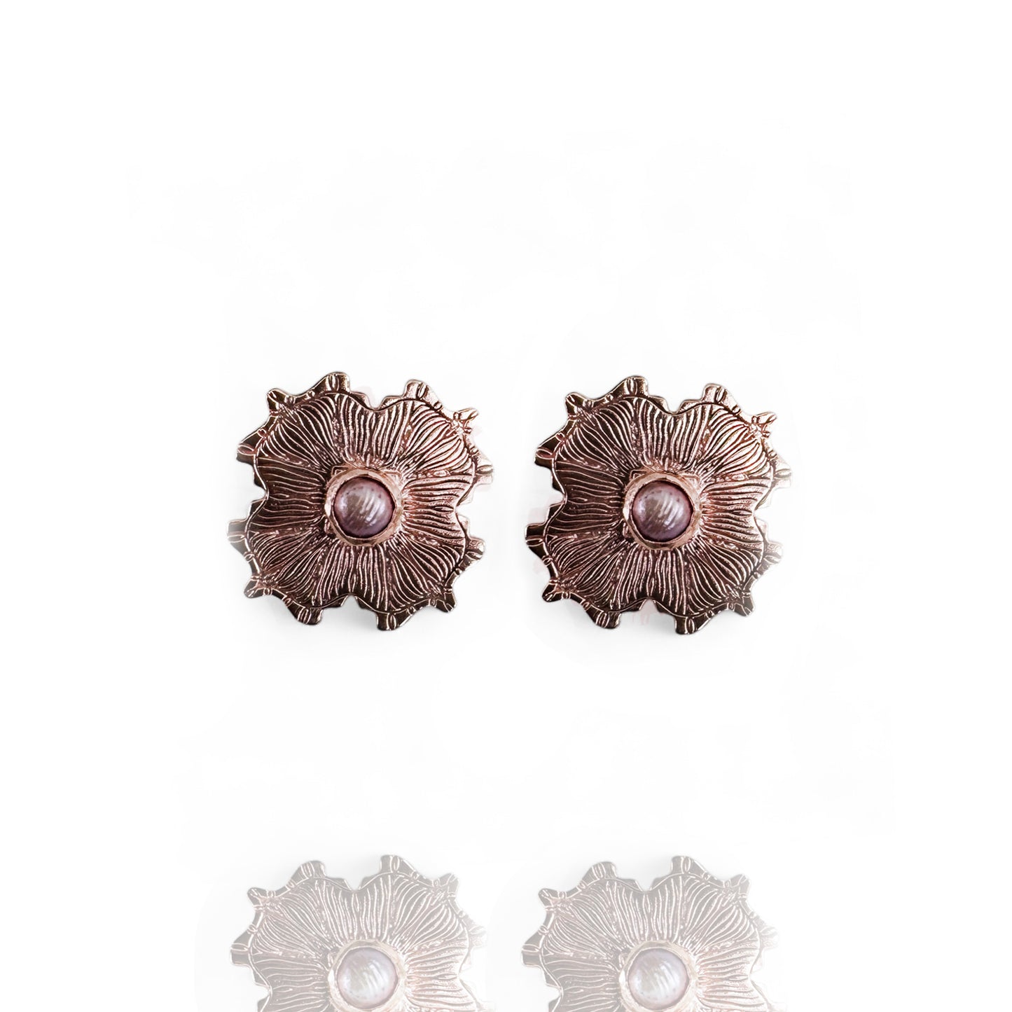 Pair of rose gold floral earrings with pearl centers on a white background