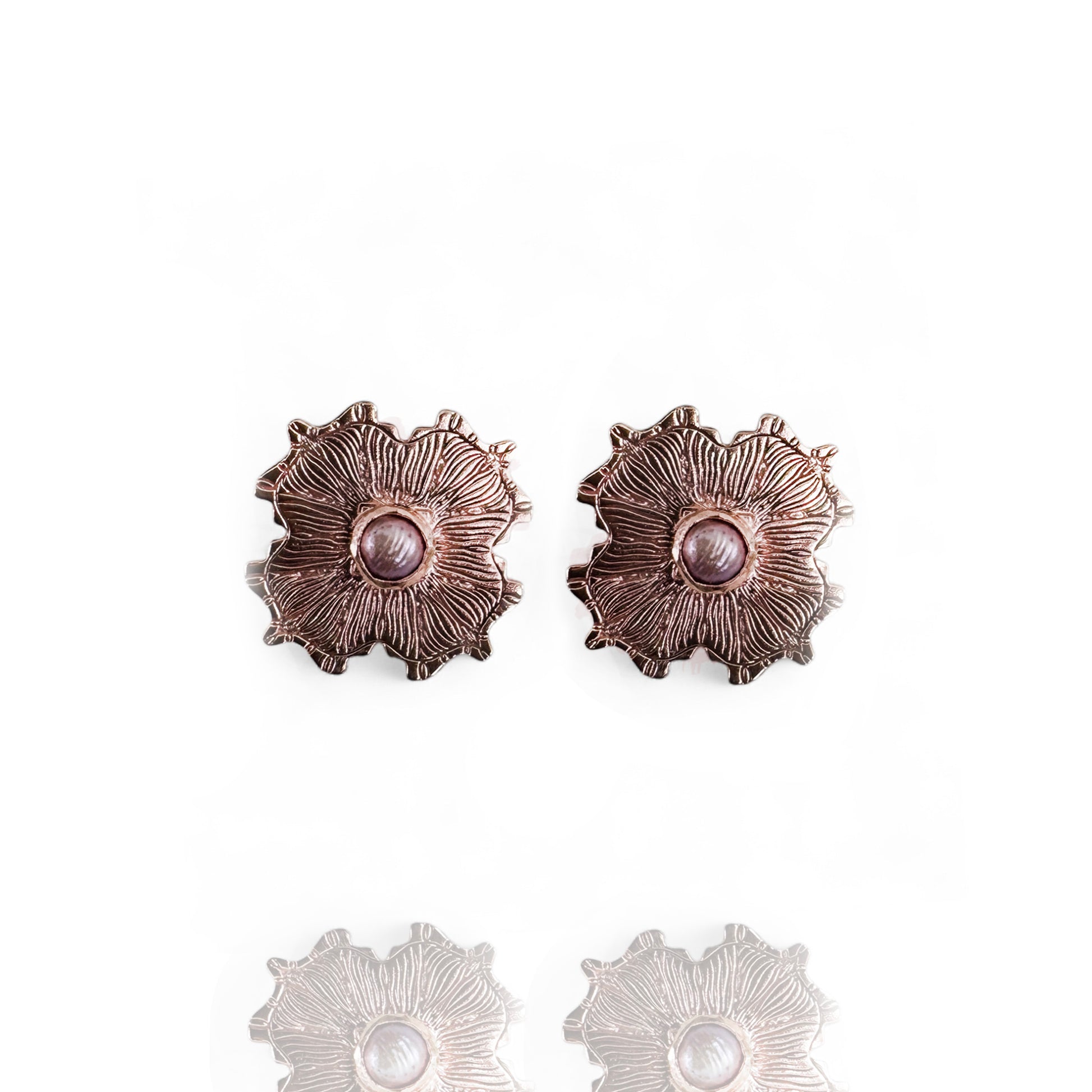 Pair of rose gold floral earrings with pearl centers on a white background
