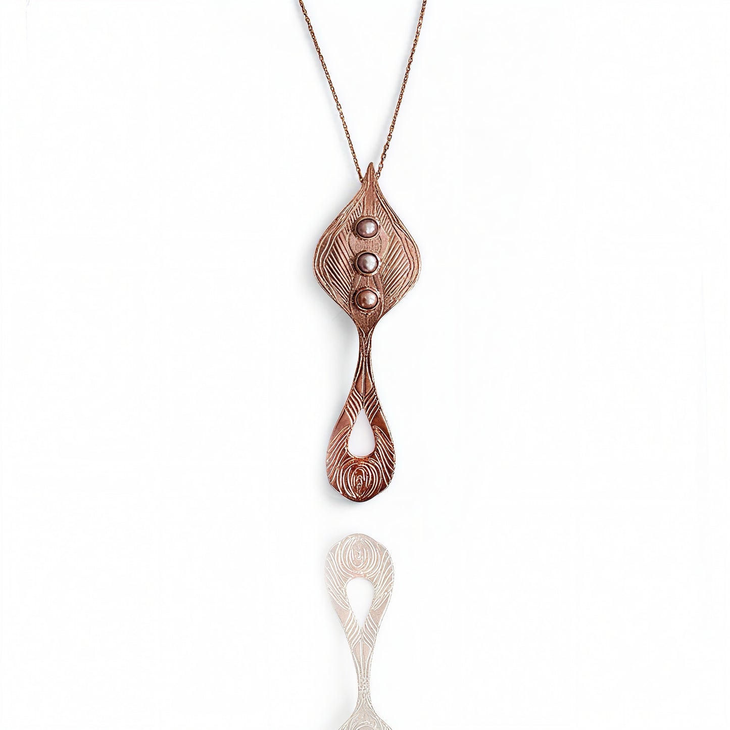 Rose gold necklace with a unique pendant on a white background