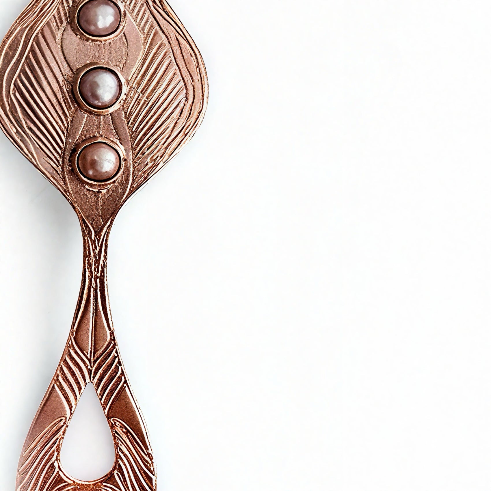 Closeup of a rose gold pendant with three pearls