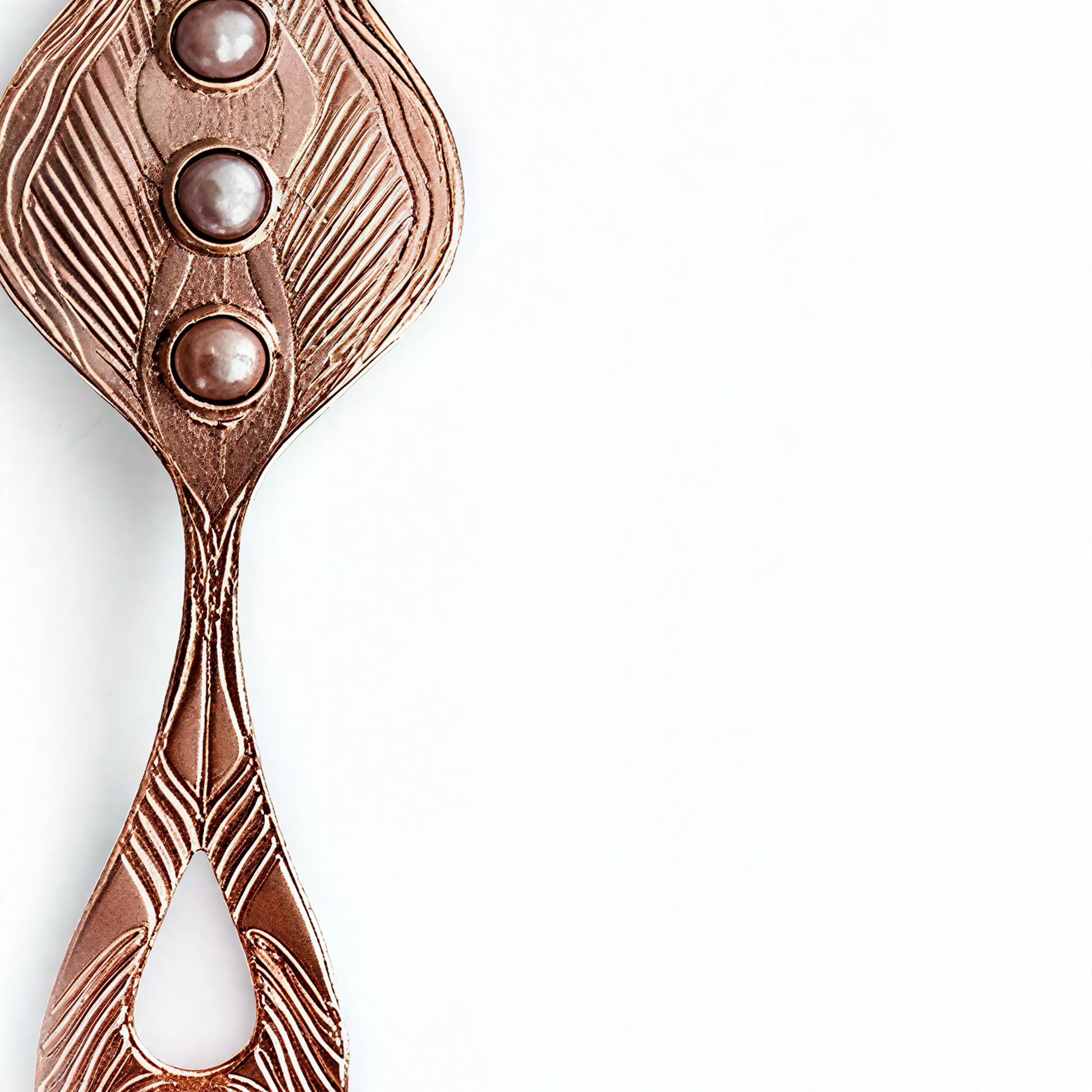 Closeup of a rose gold pendant with three pearls