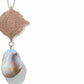 Necklace with a rose gold pendant and a large pearl pendant on a white background