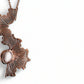 Rose gold necklace with intricate design  and pearl on a white background